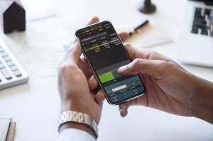 man checking stocks on a cell phone