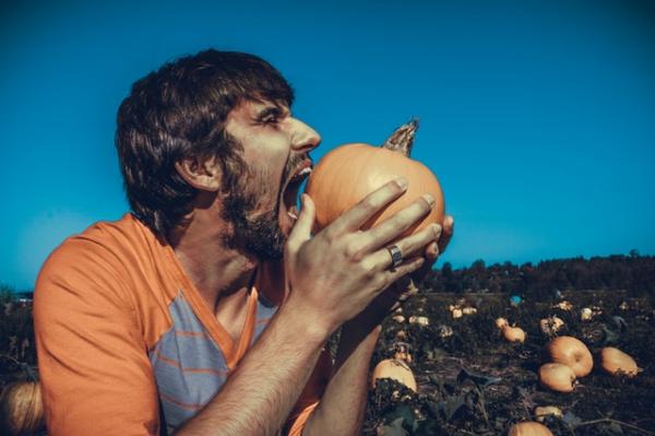 man trying to eat entire pumpkin