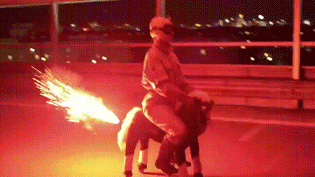 Person riding toy horse with flames shooting from behind.