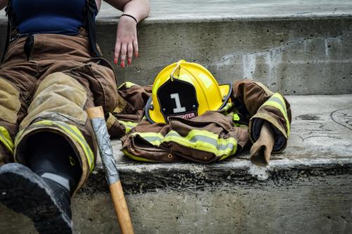 Firefighter sitting next to fire hat and jacket