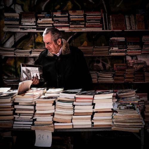 Man looking at pile of books